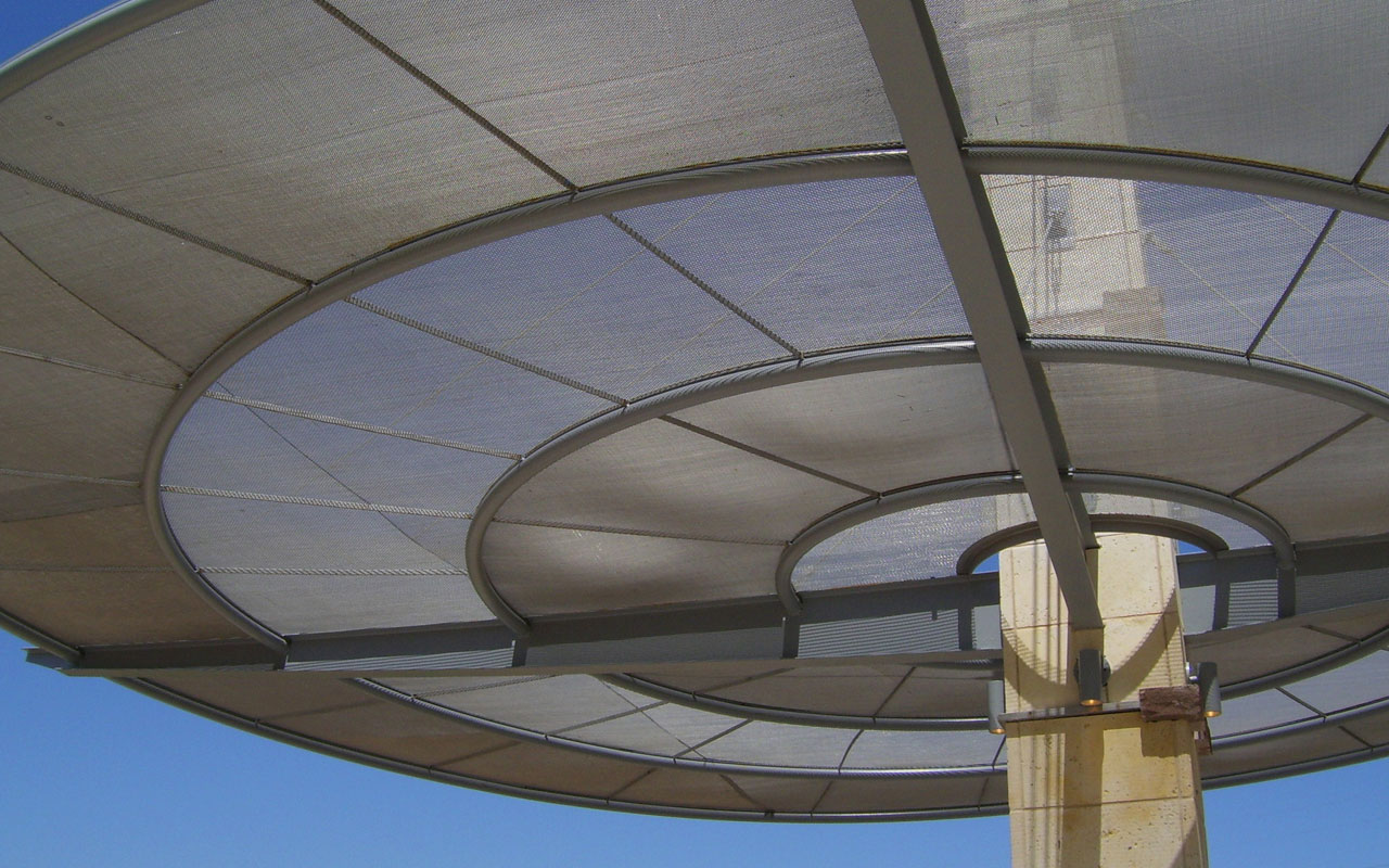 Mike Lewis Park - Grand Prairie, Texas - <br>At this open-air pavilion, cable-suspended woven wire rings of varying densities appear to hover weightlessly while providing excellent sun shading.